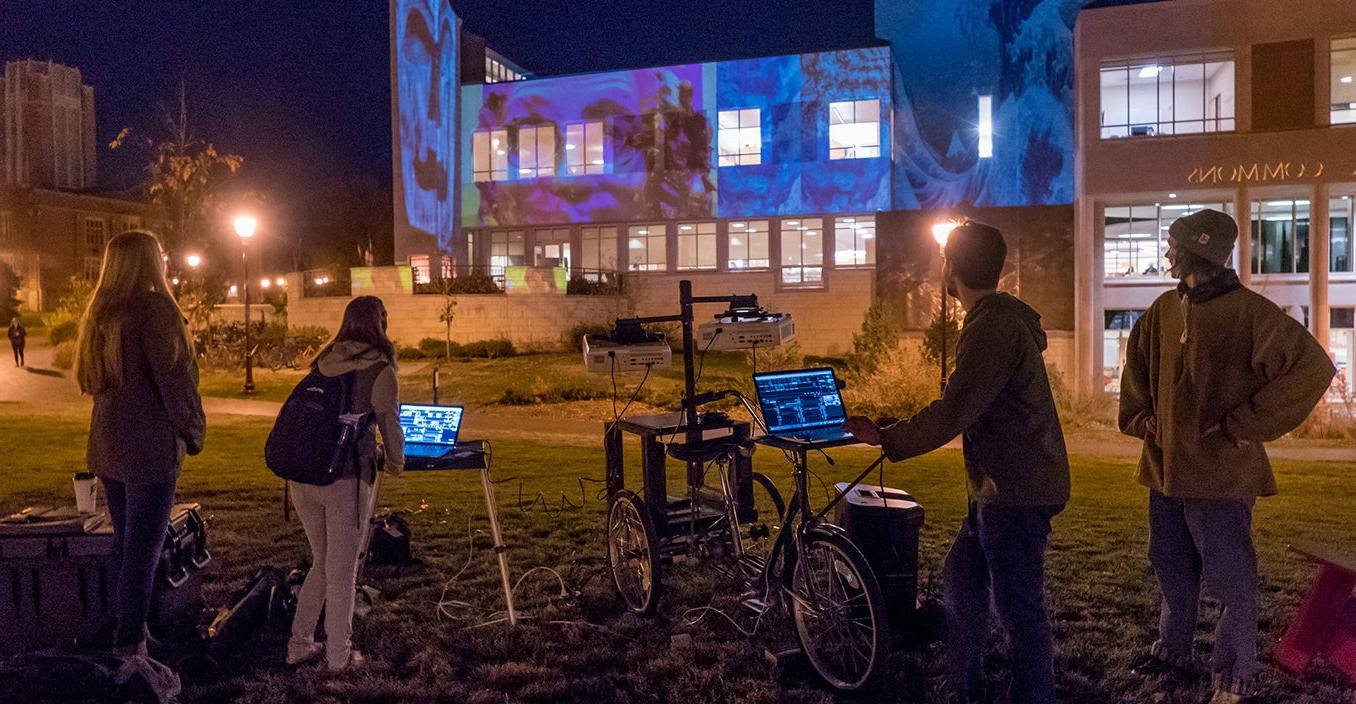 students projecting art on building